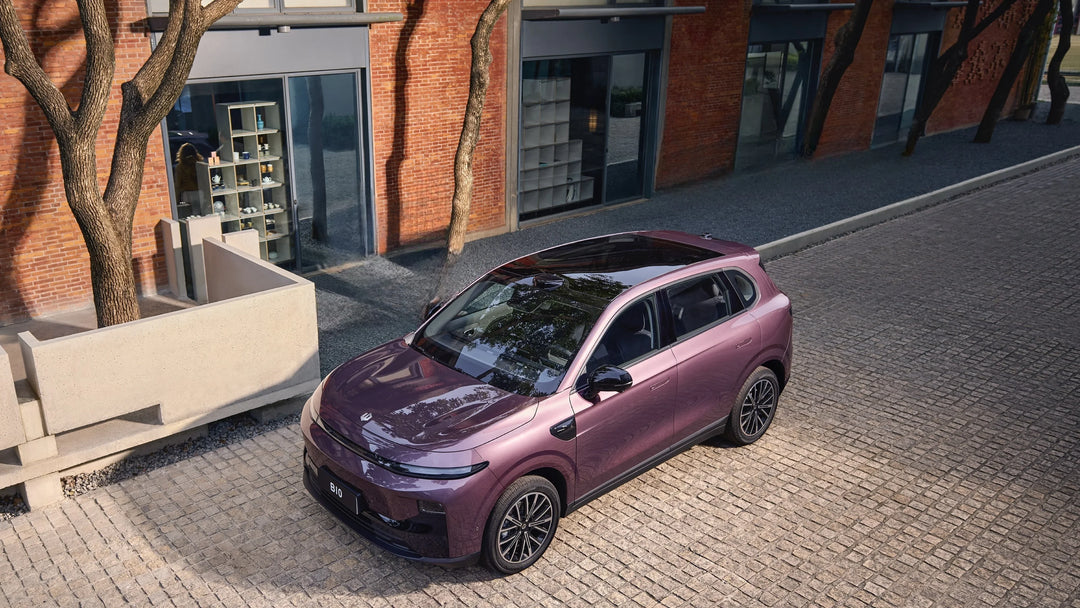 Purple Leapmotor electric SUV parked on a cobblestone street next to a modern brick building.